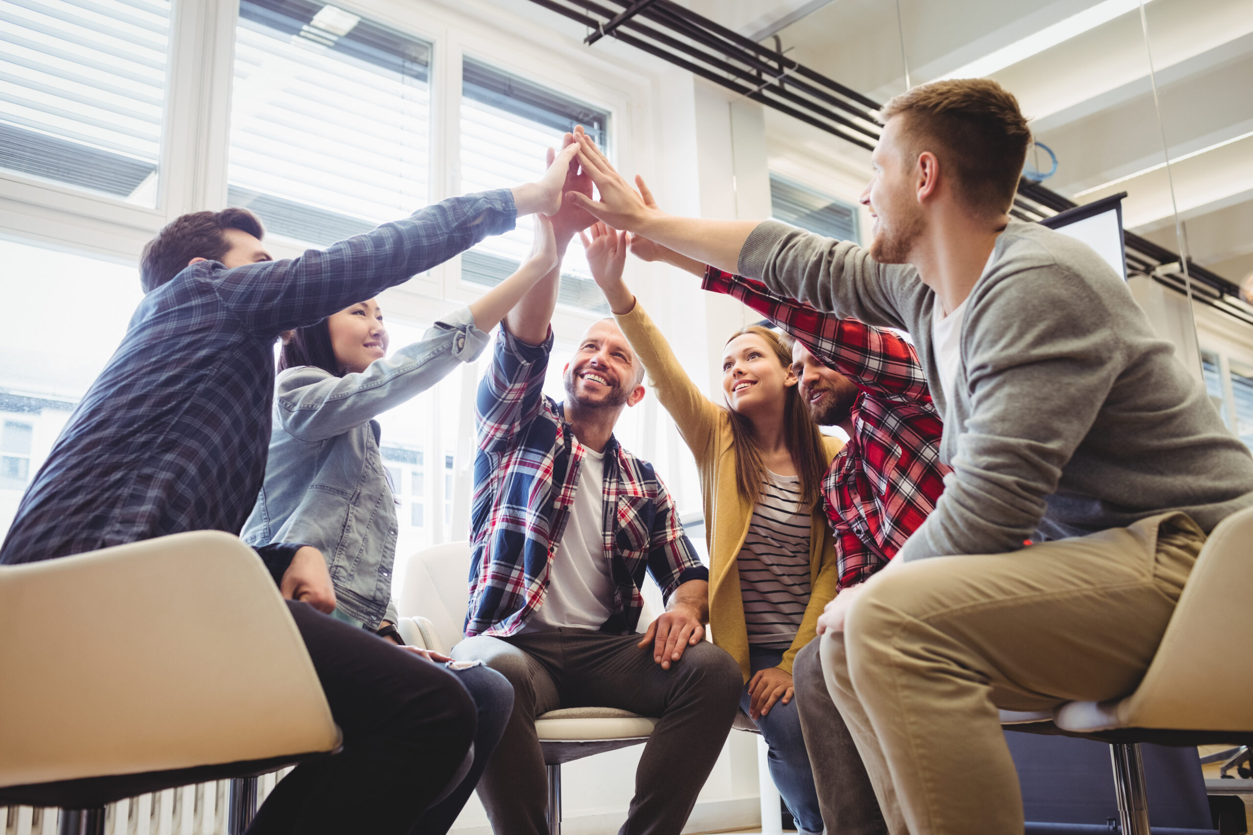 Low,angle,view,of,happy,creative,business,people,giving,high five